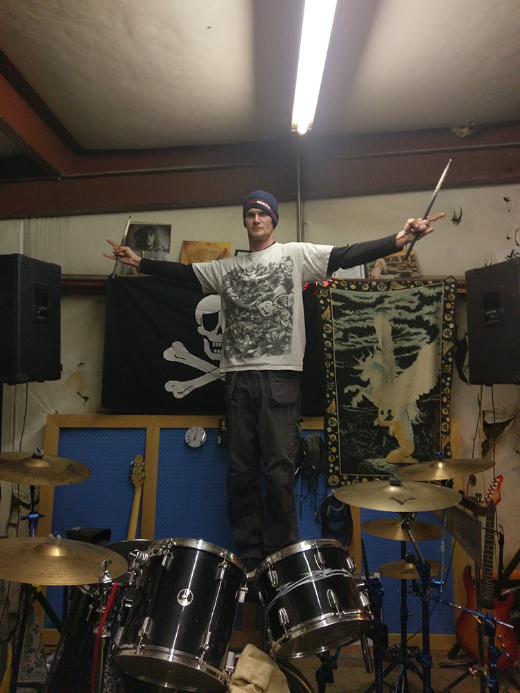 Kevin standing on his drum kit